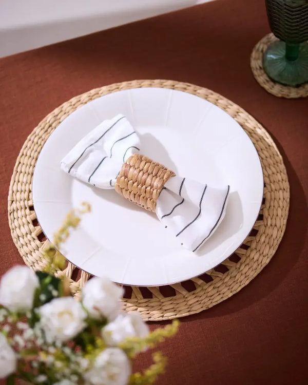 White napkin with black stripes in water hyacinth rattan ring