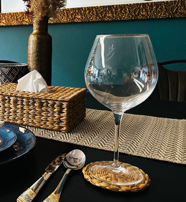 Clear crystal wine glass on water hyacinth woven coaster