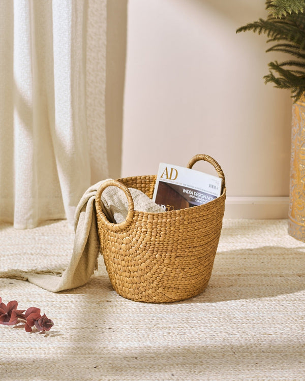 Medium water hyacinth storage basket with handles holding magazine and cloth